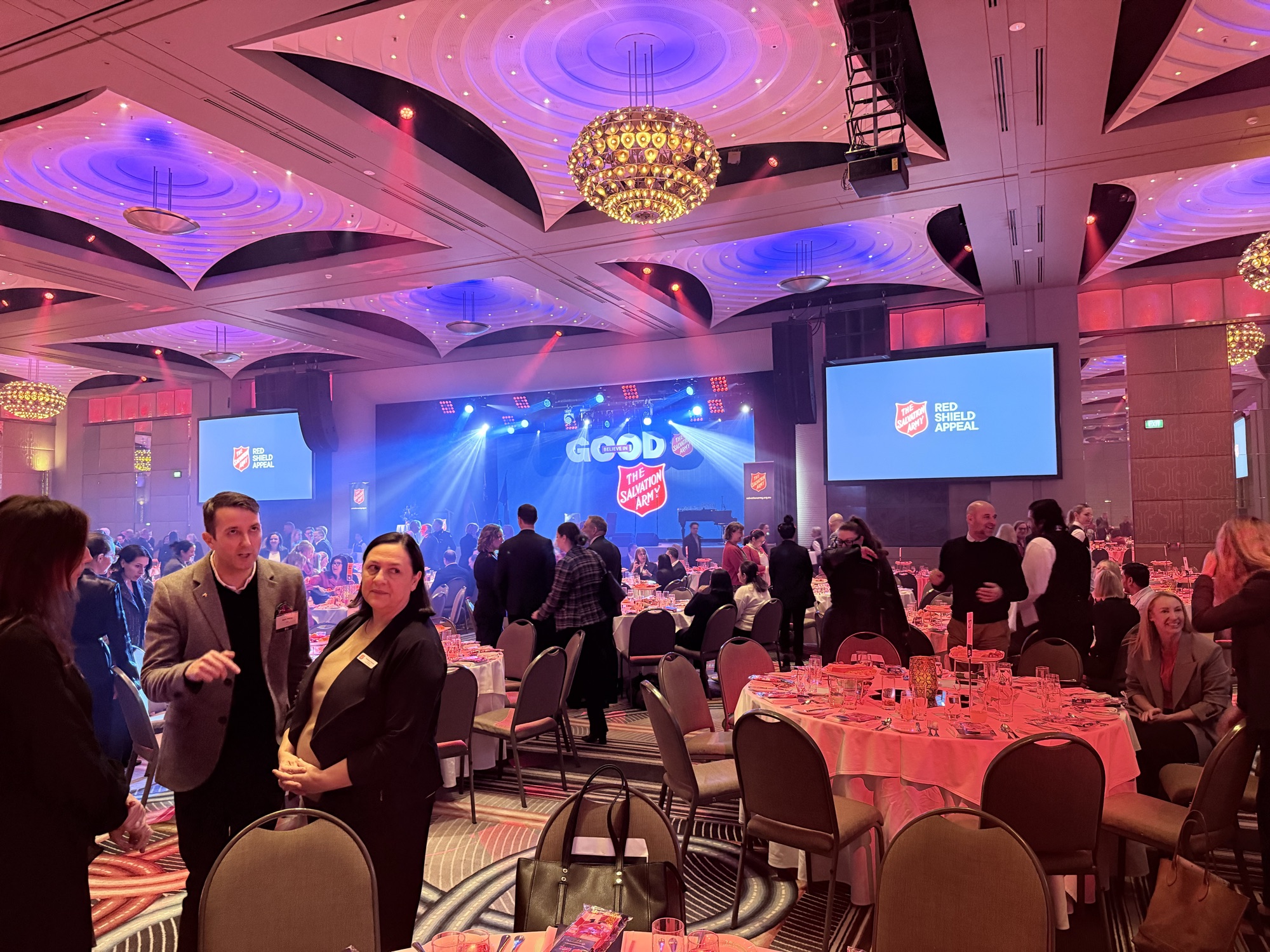 The Red Shield Appeal ballroom, stage lit, guests seated at tables